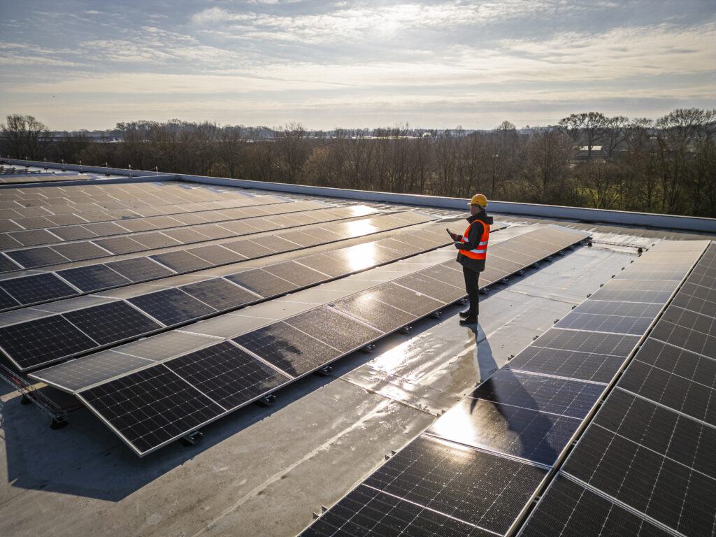 oplevering zonnepanelen door medewerker op het dak van Cuppen Logistics